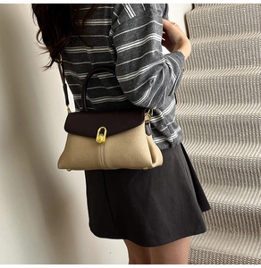 Detail of vintage color-block handbag with gold twist lock and adjustable strap