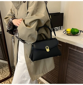 Detail of black matte leather handbag with gold metal interlocking oval clasp closure