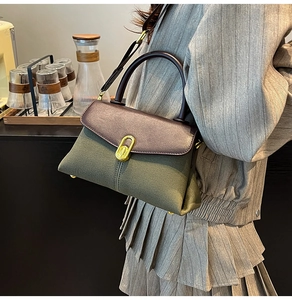 Side view of vintage leather canvas patchwork handbag with golden swivel lock detail