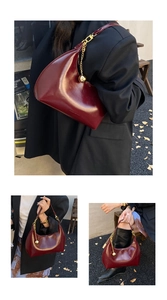 Dettaglio della borsa hobo in vernice bordeaux lucida con catena e ciondolo dorato