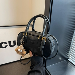 Sac cylindrique noir rétro avec gaufrage AIRM et breloque peluche, vue de profil