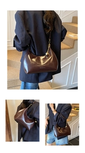 Dettaglio della borsa hobo marrone scuro con texture in pelle e catena dorata con sfera