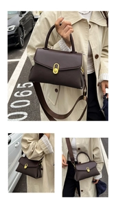 Close-up of a coffee brown lychee leather handbag featuring a gold oval twist lock closure