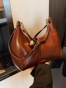 Borsa a mezzaluna chic in pelle marrone con ciondolo a sfera dorato e tracolla sottile