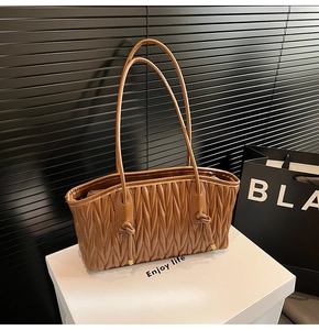 Détail du sac cabas marron foncé avec texture matelassée verticale et nœud élégant