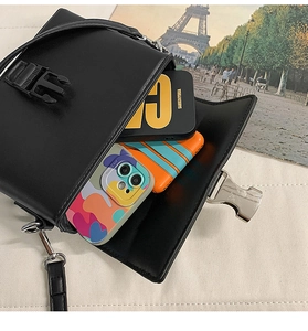 Detail showing internal storage of a black PU leather crossbody bag with buckle