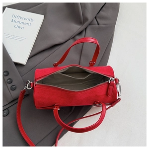Top view of red cylinder bag showing fabric lining interior and silver zipper closure