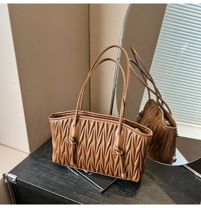 Vue détaillée du sac cabas plissé marron foncé avec texture Matelassé verticale et fines anses