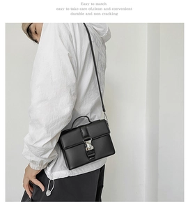 Minimalist black PU crossbody bag with silver buckle worn by a model in a white hoodie