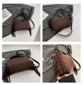 Detail view of brown suede crossbody bag with tassels and woven handle texture