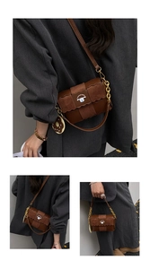 Detail of brown suede shoulder bag with gold chain strap and donut charm accessory