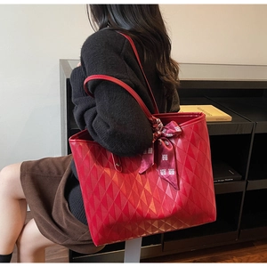 Detalle del bolso tote acolchado rojo con pañuelo de seda y motivos festivos