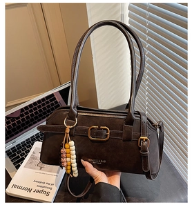 Detail of dark brown vintage faux leather shoulder bag with decorative wooden beads