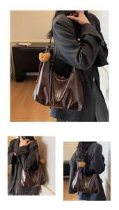 Detail of soft dark brown leather shoulder bag with vintage gloss and plush bear charm