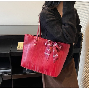 Detalle de bolso tote rojo grande con textura ondulada y pañuelo de seda tradicional
