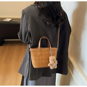 Brown quilted suede bucket bag with GF logo, leather handle, and plush bear charm detail