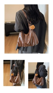 Detail of dark brown leather hobo bag with a cute orange teddy bear charm pendant