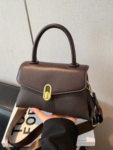 Retro dark brown top handle bag with golden oval twist lock and a wide shoulder strap