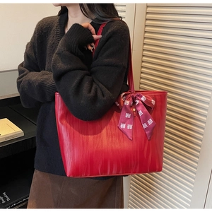 Detalle del bolso tote rojo con textura y lazo de seda con motivos tradicionales chinos