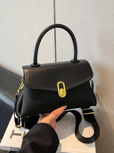 Classic black leather trapezoid handbag with gold oval twist lock and wide fabric strap