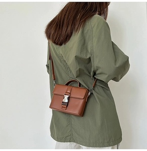 Detailed back view of model wearing a vintage brown PU leather small crossbody bag