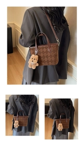 Detail of vintage brown bucket bag featuring quilted texture and cute teddy bear charm