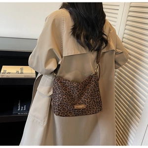 Détail du sac bandoulière à motif léopard avec sangle en cuir brun et dorure chic