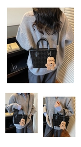 Three-way view of a black patterned tote bag with a cute plush bear charm accessory