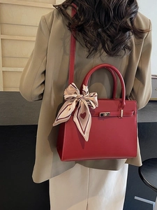 Sac à main élégant en cuir rouge pour femme avec fermoir doré et foulard décoratif en soie