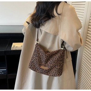 Détail du sac cabas léopard tendance avec patch logo en cuir et bandoulière fine