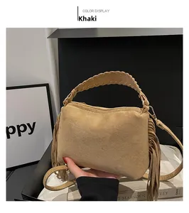Macro detail of khaki suede shoulder bag featuring long tassels and woven top handle