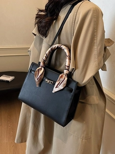 Sac à main chic en cuir noir avec fermoir doré et détail de foulard en soie