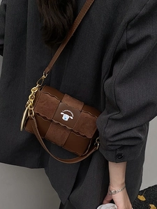 Retro brown woven flap crossbody bag with gold chain strap on grey blazer model