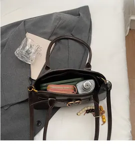 Interior view of dark brown large capacity tote bag with phone and bottle inside
