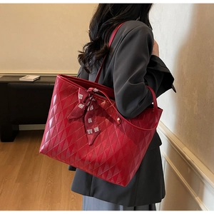 Detalle del bolso tote rojo acolchado con lazo de boda chino y textura de rombos