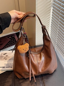 Brown faux leather hobo bag with fringe detail and a cute plush bear keychain charm