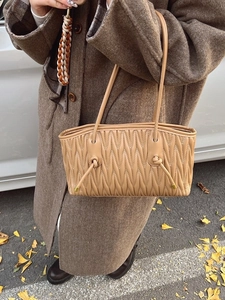 Sac fourre-tout plissé beige avec texture en V sur un manteau en laine marron d'hiver