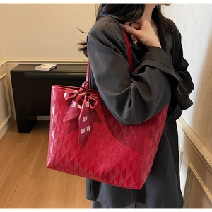 Detalle del bolso tote rojo acolchado con cinta de boda y gran capacidad de almacenaje