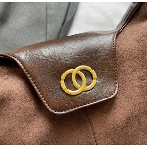 Macro view of brown lychee leather bag with elegant golden double-ring metal buckle