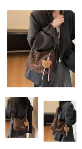 Détail du sac hobo léopard avec breloque ours en peluche et bandoulière en cuir