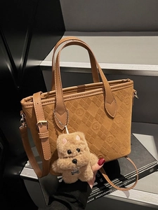 Brown faux suede bucket bag with quilted patterns and a cute dog plush keychain