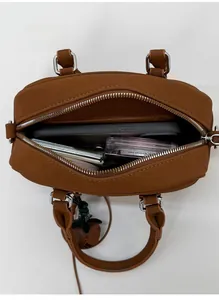 Interior view of tan mini bowling bag showing storage for phone and cosmetics