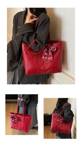 Detail view of red tote bag with wave texture and festive Chinese wedding bow ribbon
