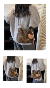 Détail du sac cabas léopard avec pendentif ours et accessoire de pompon tissé