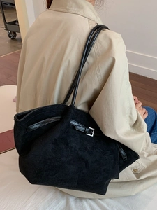 Large black suede tote bag with slim shoulder straps and metal buckle for daily commute