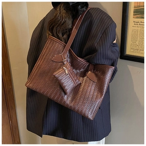 Détail de la texture tressée et du porte-monnaie amovible sur le sac cabas marron