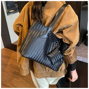 Détail du grand sac cabas noir tissé avec pochette zippée assortie porté par le mannequin