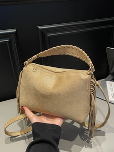 Camel suede shoulder bag with fringe detailing and woven handle shown from the side
