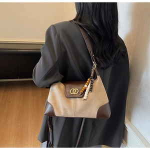 Detail of retro patchwork shoulder bag with suede fabric and gold ring metal buckle