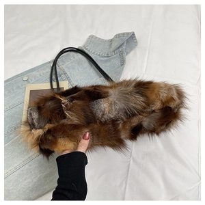 Detail showing the fluffy texture of a brown faux fur underarm bag with black slim handle